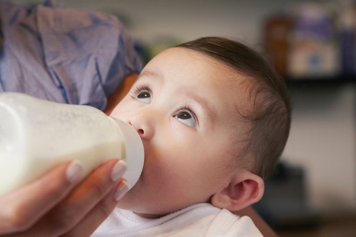 Baby girl drinking bottle of milk