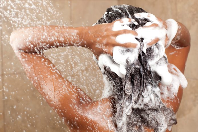Woman washing her hair with shampoo