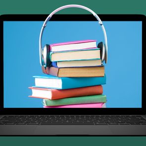 laptop with a stack of books with headphones around them popping off the screen; green background