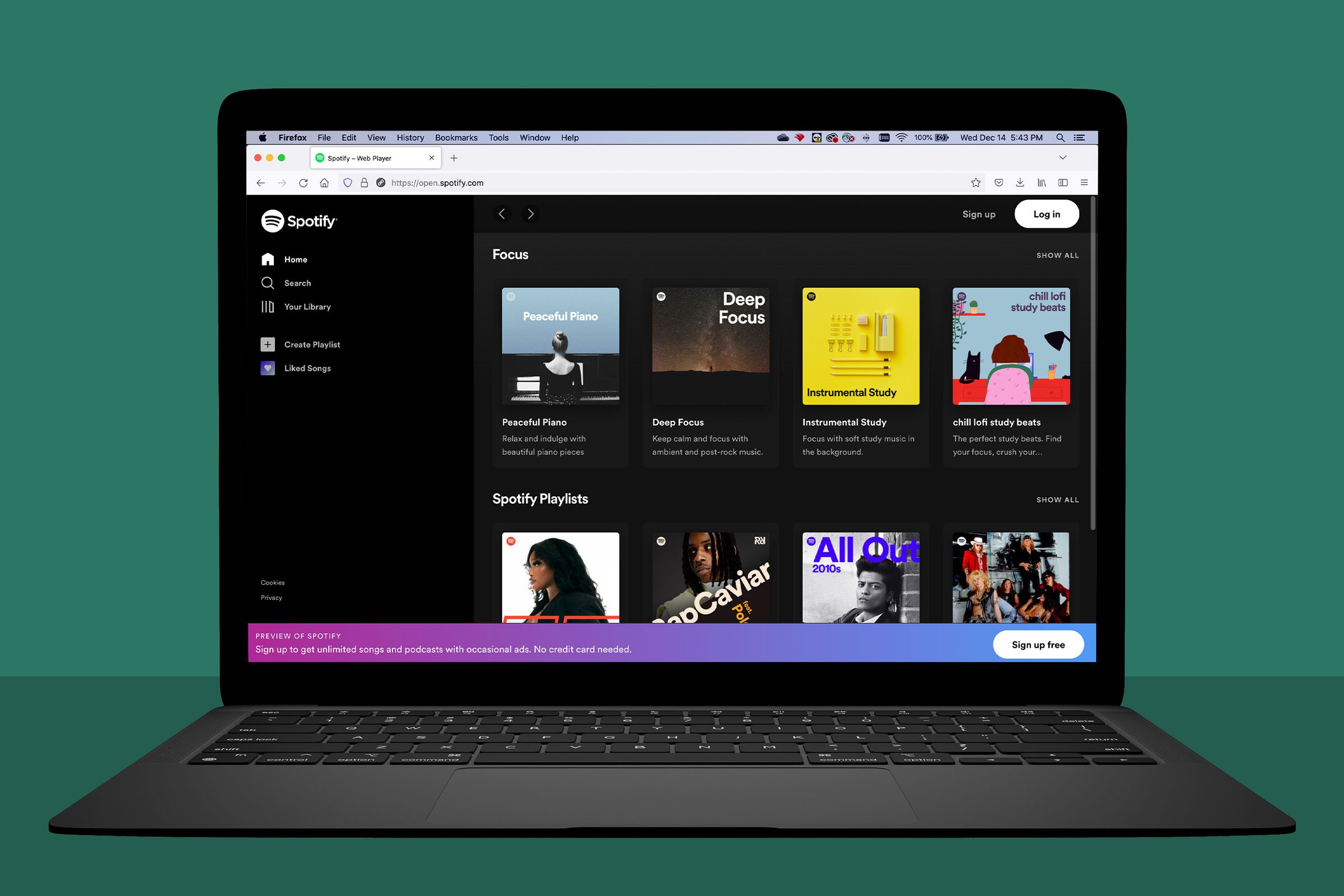 laptop showing spotify.com; green background