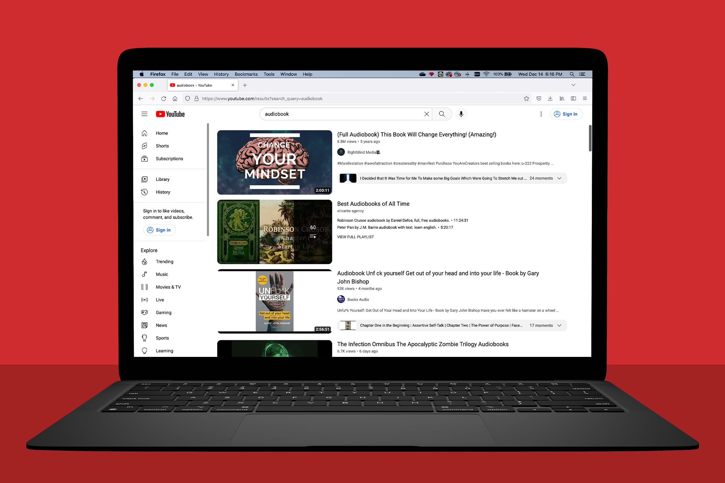laptop showing a search for audiobooks on youtube; red background