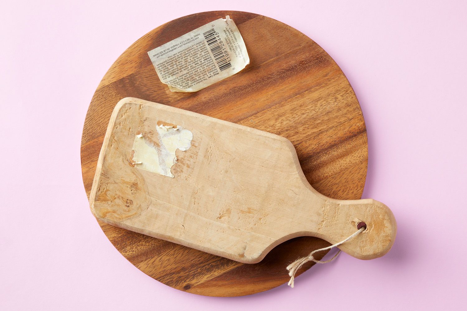 partially removed stickers and residue stick to wood boards, on pink background
