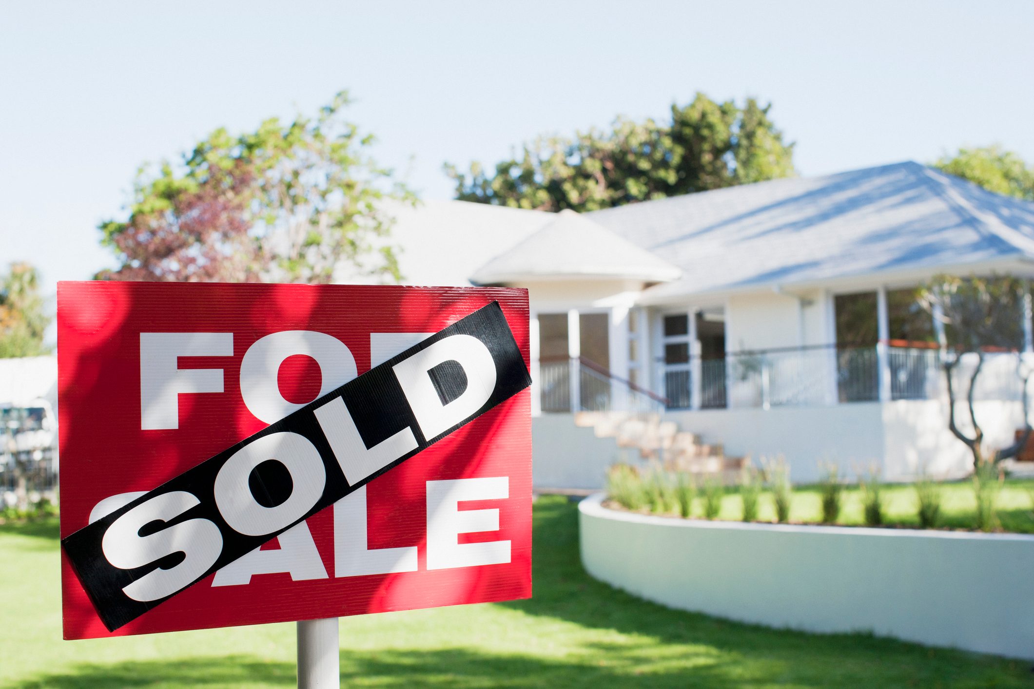 Sold sign in front yard of house