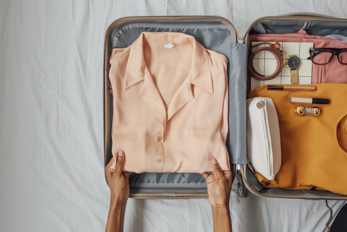 A Woman Packing her Clothes in a Suitcase