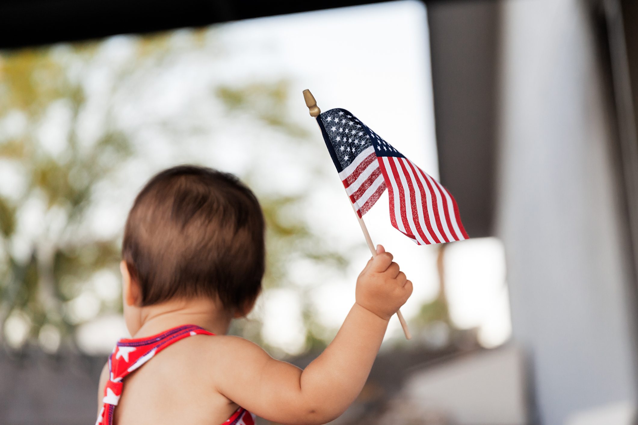 Rear View Of Baby Girl Holding American Flag