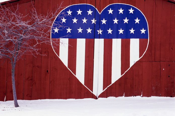 The side of a red barn in Eastern Washington State is decorated with a large heart containing the Stars and Stripes.