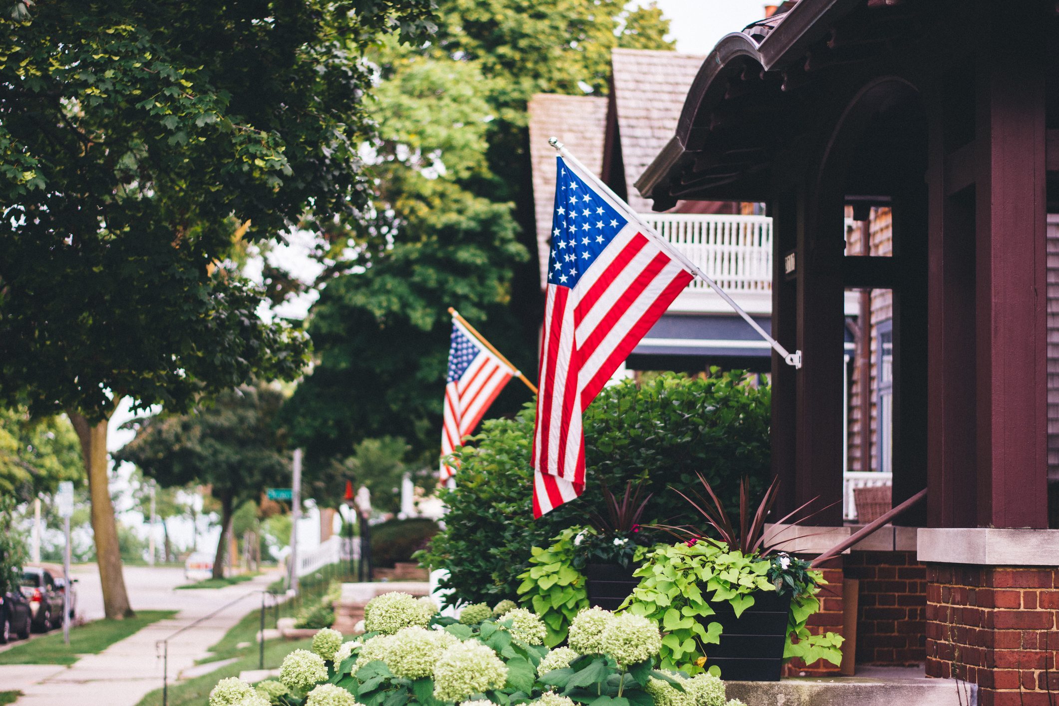 American Flags On consecutive houses along a quaint neighborhood street