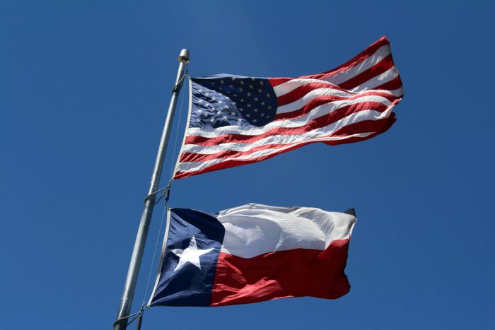 Low Angle View Of Flags Against Clear Blue Sky