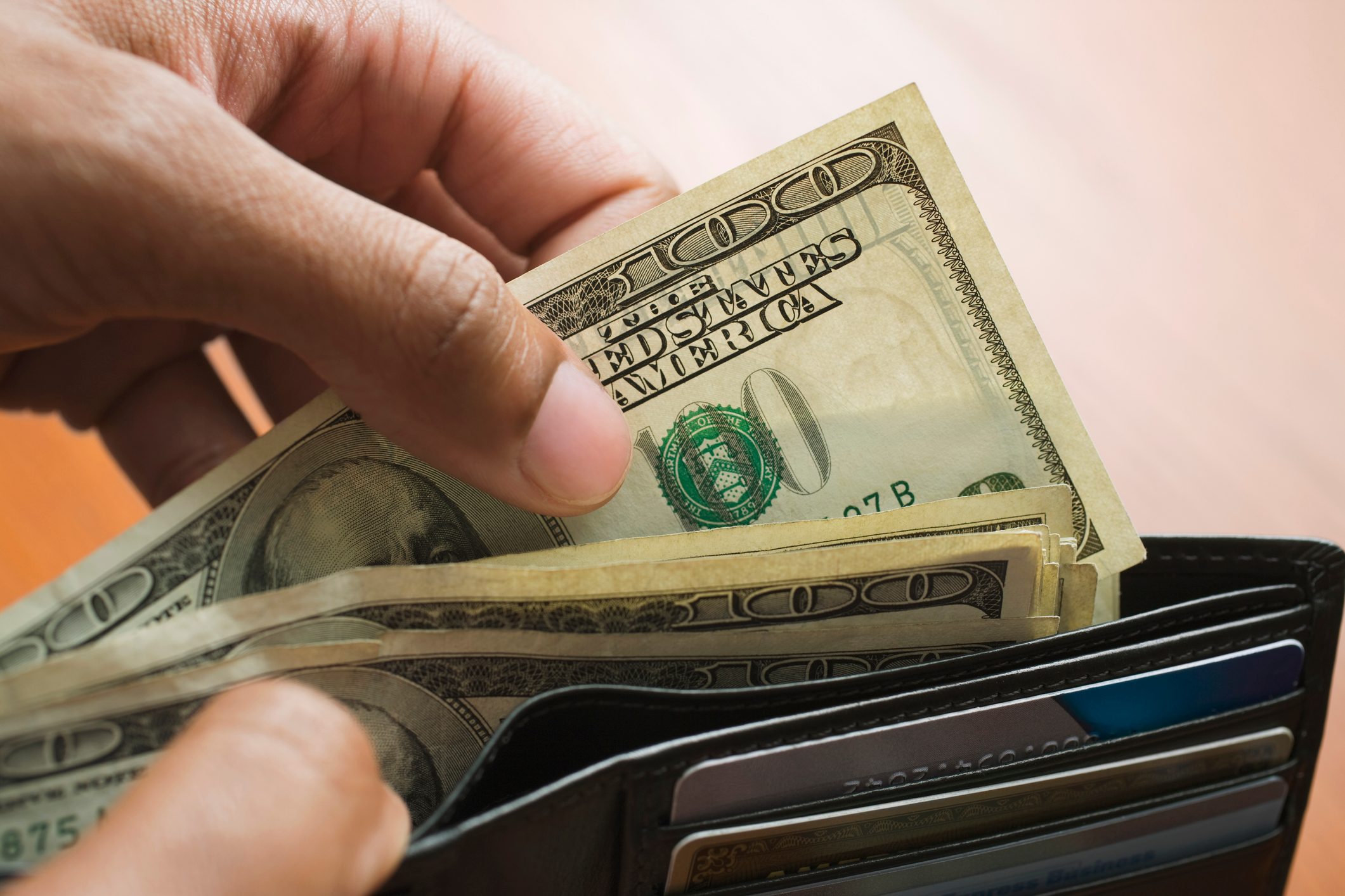 Mixed Race man taking money out of wallet