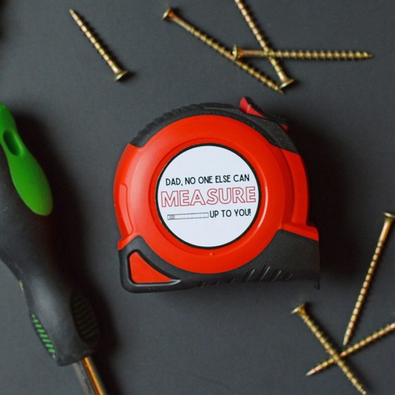 Fathers Day measuring tape surrounded by nails and screwdrivers