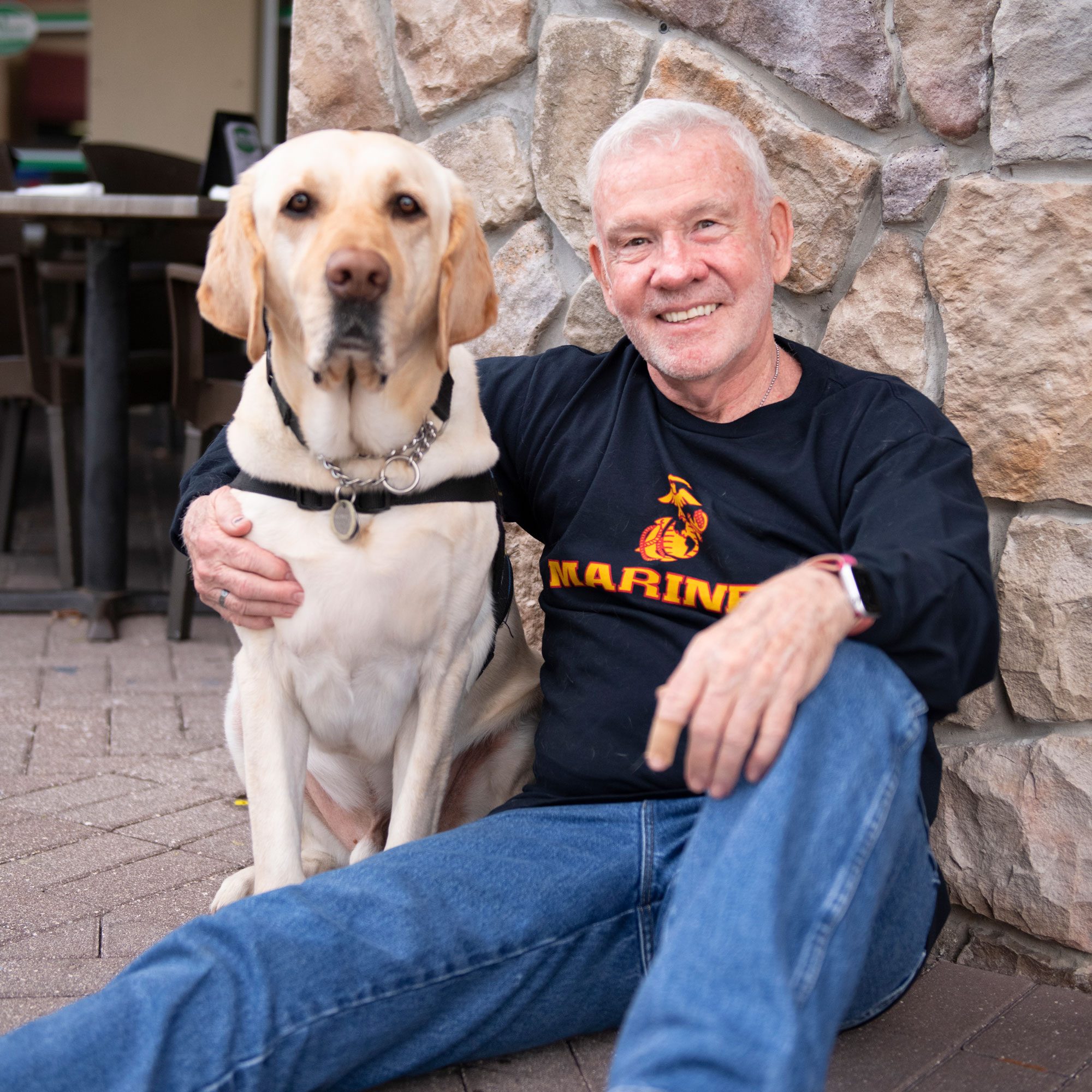 a veteran and his service dog sit together
