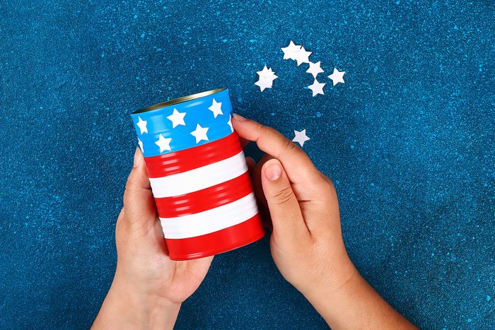 Diy vase 4th of July craft from tin can, electrical tape colors of the American flag, red, blue and white.