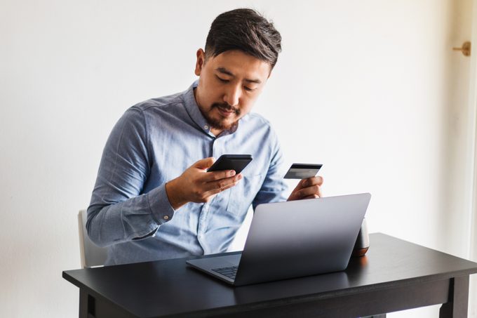 Serious man making online purchase