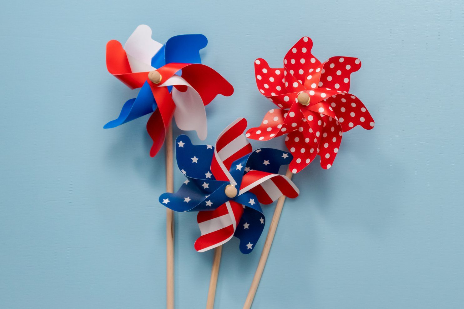 July 4th theme paper pinwheels on blue background.