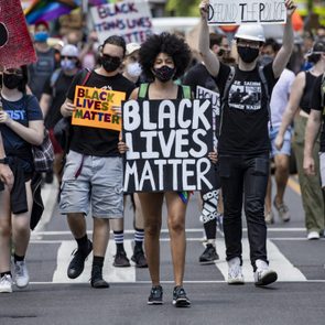 A woman walks among a marching crowd with a 