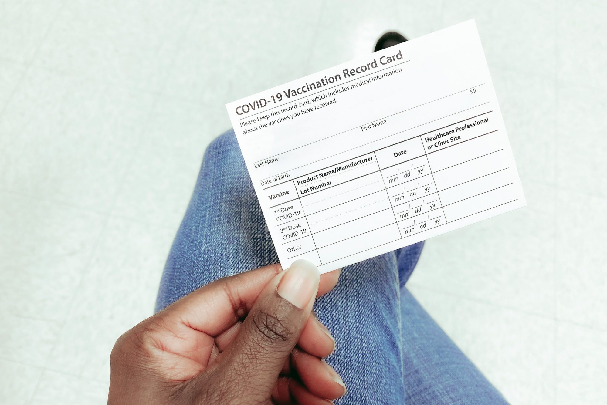 Woman Holds COVID-19 Vaccination Record Card