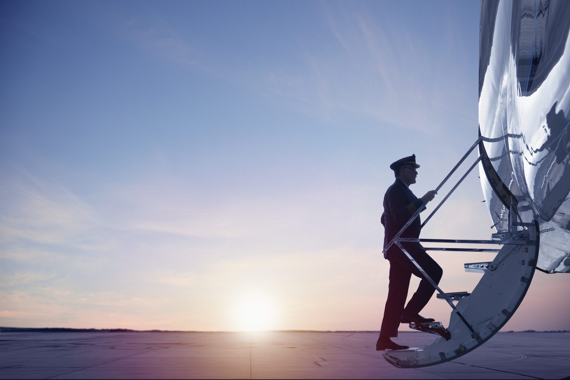 Caucasian pilot walking up steps of jet