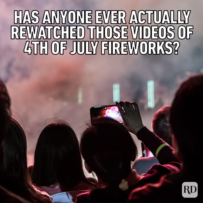 group of people watching and recording fireworks