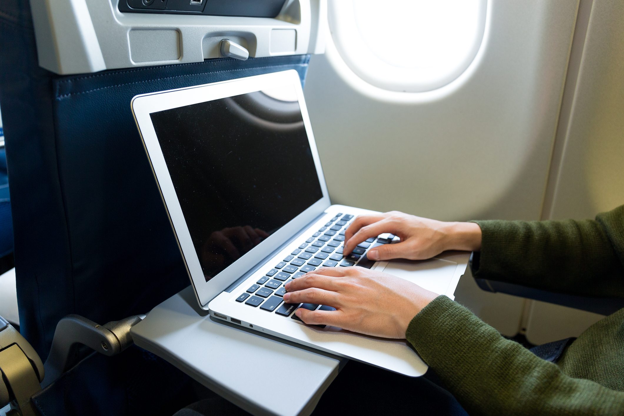 Woman using laptop computer on airplane