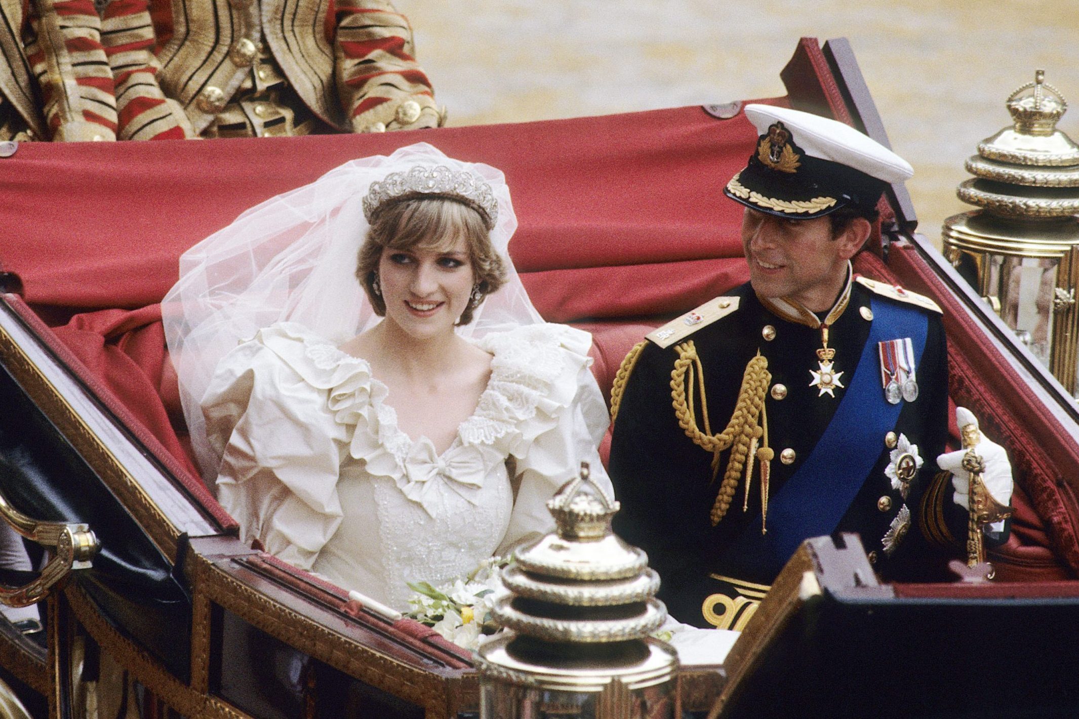 Prince Charles, Prince of Wales and Diana, Princess of Wales, wearing a wedding dress designed by David and Elizabeth Emanuel and the Spencer family Tiara, ride in an open carriage, from St. Paul's Cathedral to Buckingham Palace, following their wedding on July 29, 1981 in London, England.