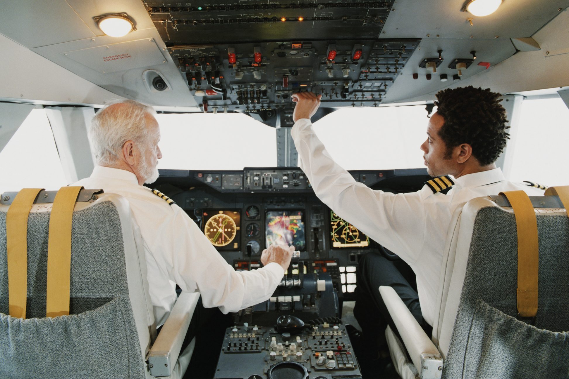 Portrait of Pilots Sitting in the Cockpit, Adjusting the Controls