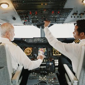 Portrait of Pilots Sitting in the Cockpit, Adjusting the Controls