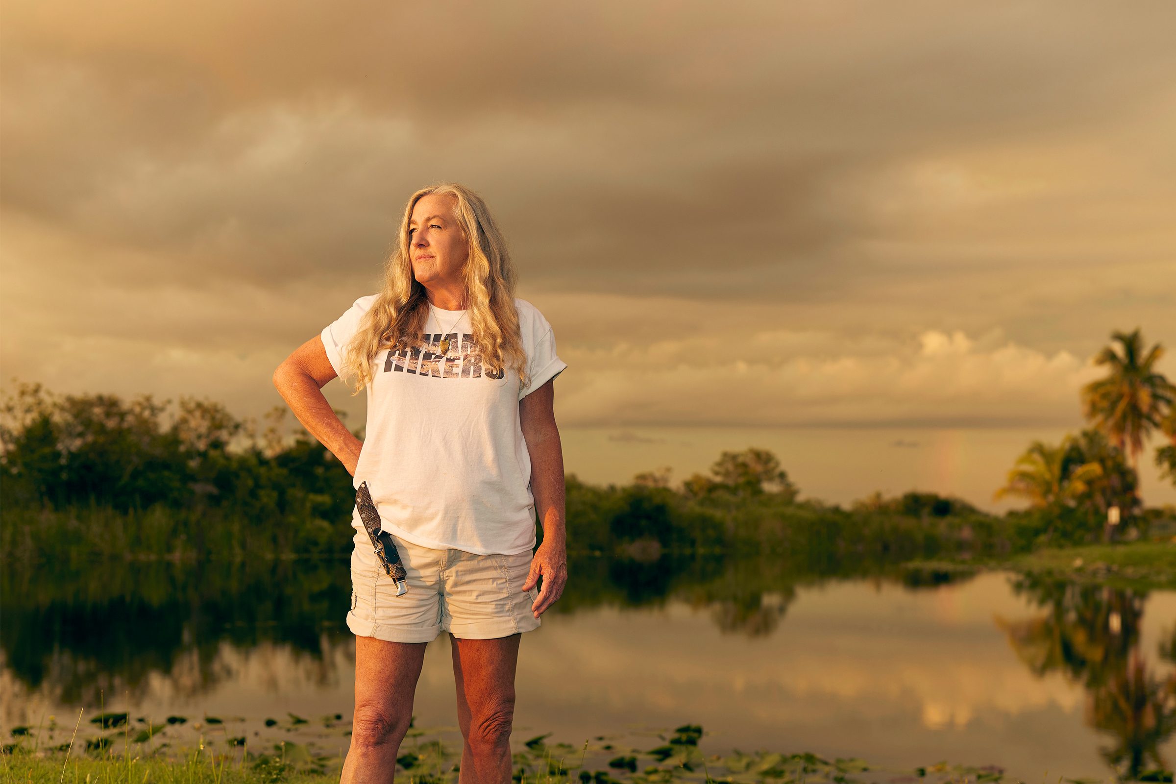 Anne Gorden-Vega with a knife in a snakeskin holster on her hip standing in front of the Everglades