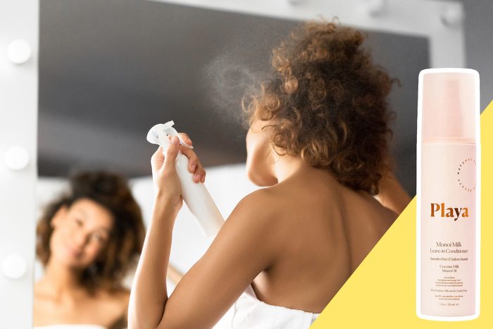 woman spraying leave in conditioner into her hair