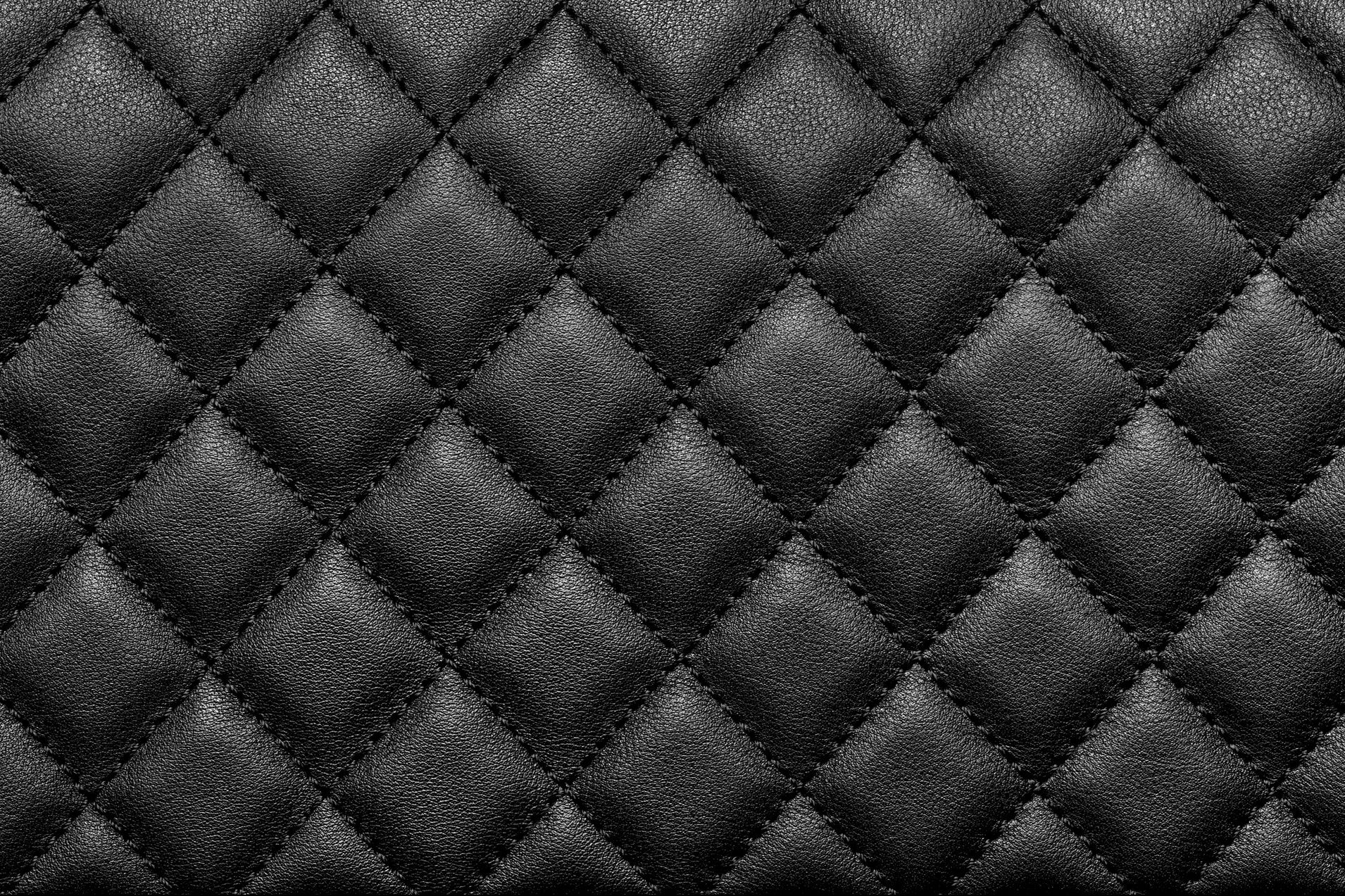 Close-up texture of genuine leather with black rhombic stitching