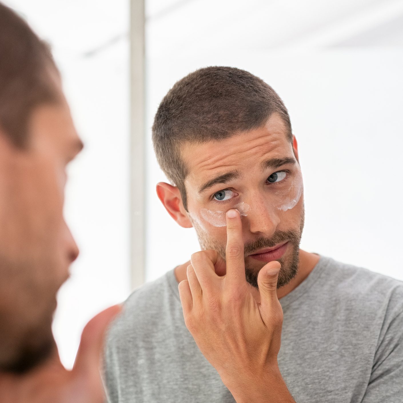 Man applying moisturizer under eyes
