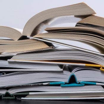 Stack Of Open Books On Table