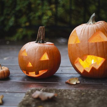 Lit jack-o-lanterns on doorstep outside