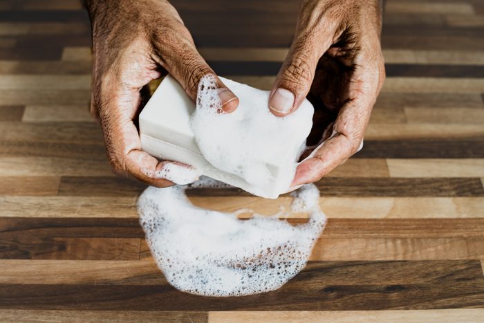 An old man washing his hands with a bar of soap