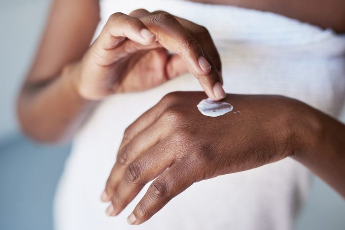 womans hands rubbing in a dab of moisturizer cream