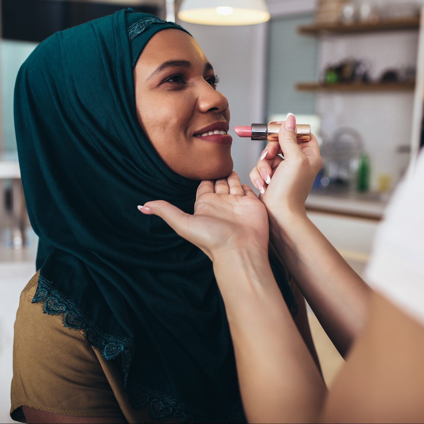 close up of a makeup artist applying lipstick to young woman