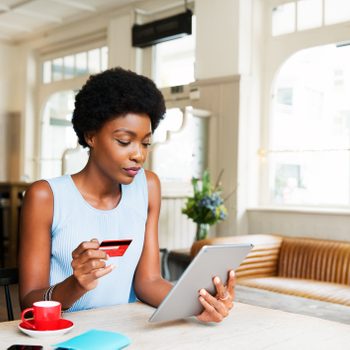 Woman with credit card and tablet