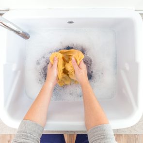 hand washing laundry in the sink