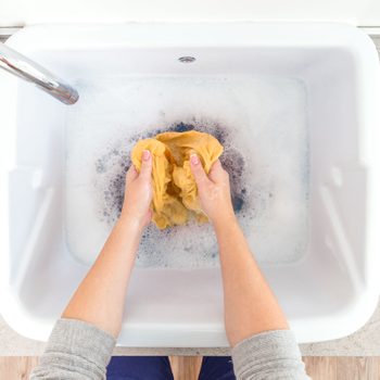 hand washing laundry in the sink