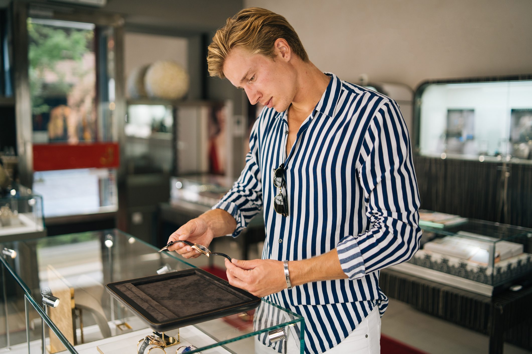 Young man smiles while shopping for watch