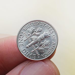 close up of someone holding a dime coin