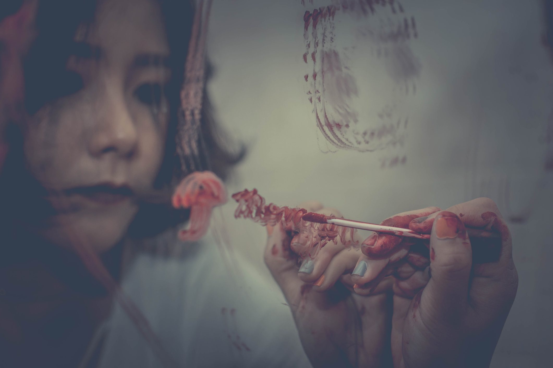 woman drawing on mirror with red lipstick