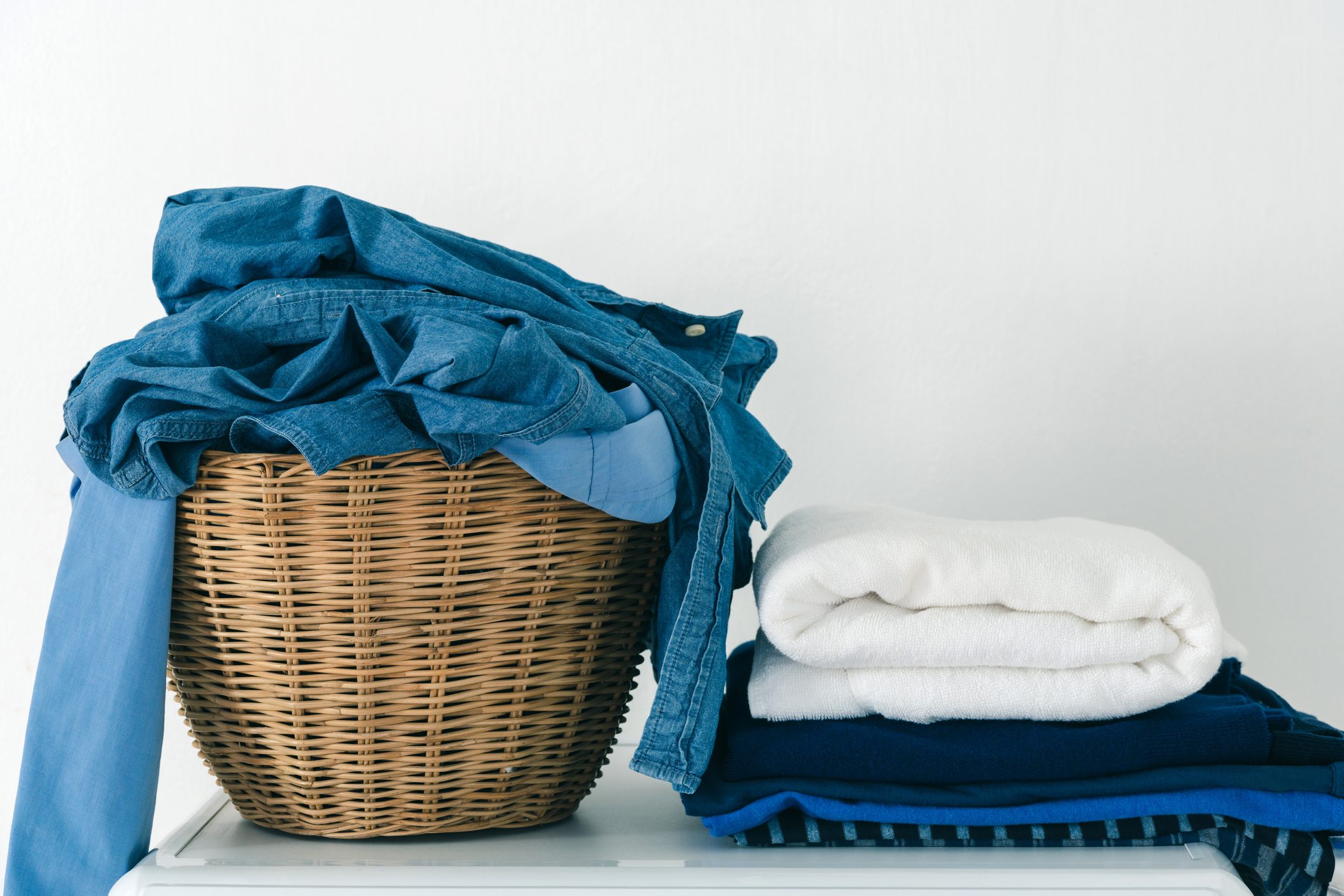 Close-Up Of Silk And Cloth In Basket Against White Wall