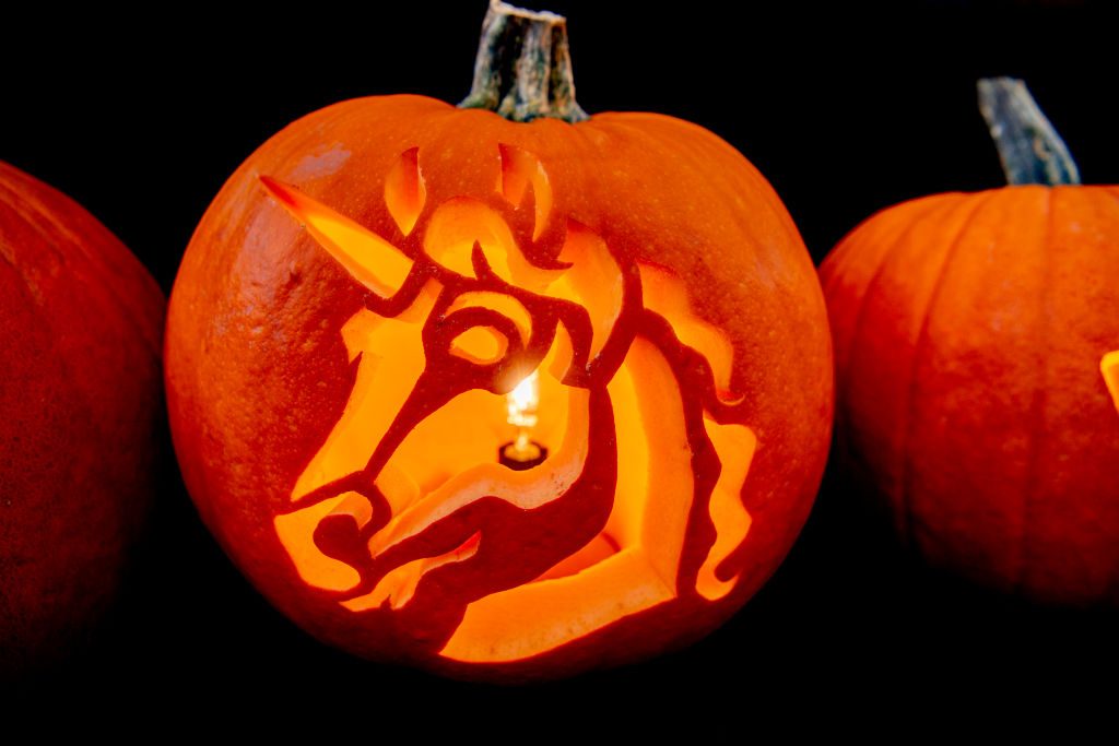 a unicorn carved into a pumpkin with a candle inside