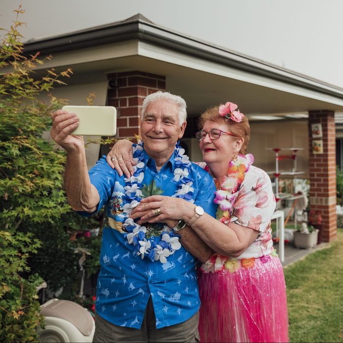 senior couple dressed as tourists while taking a selfie