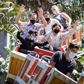 Theme park goers wear face masks as they ride a roller coaster