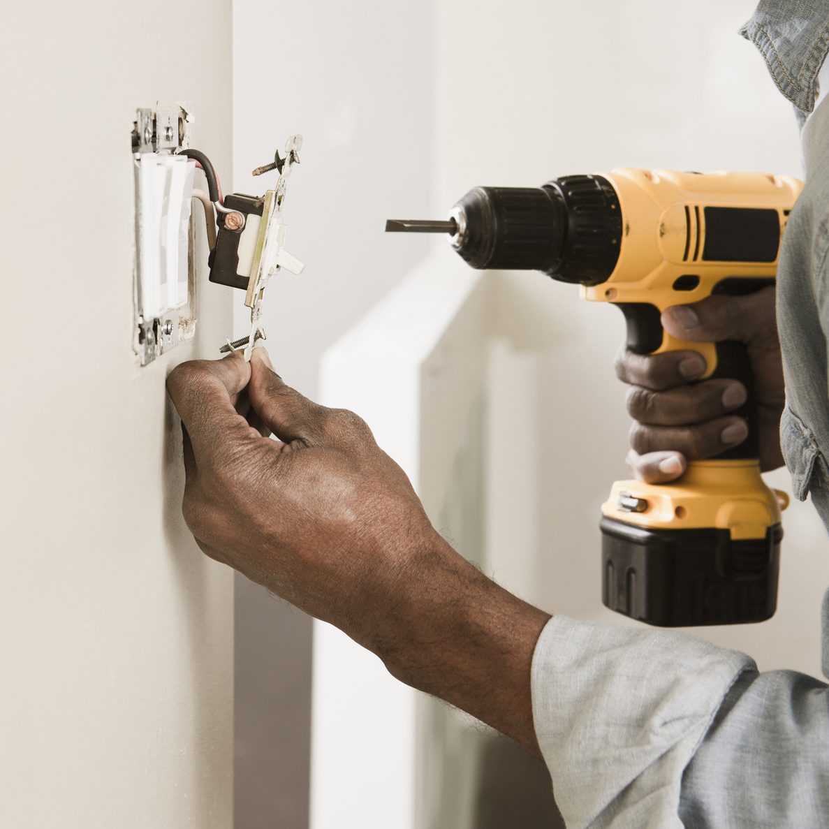 African American man using cordless drill