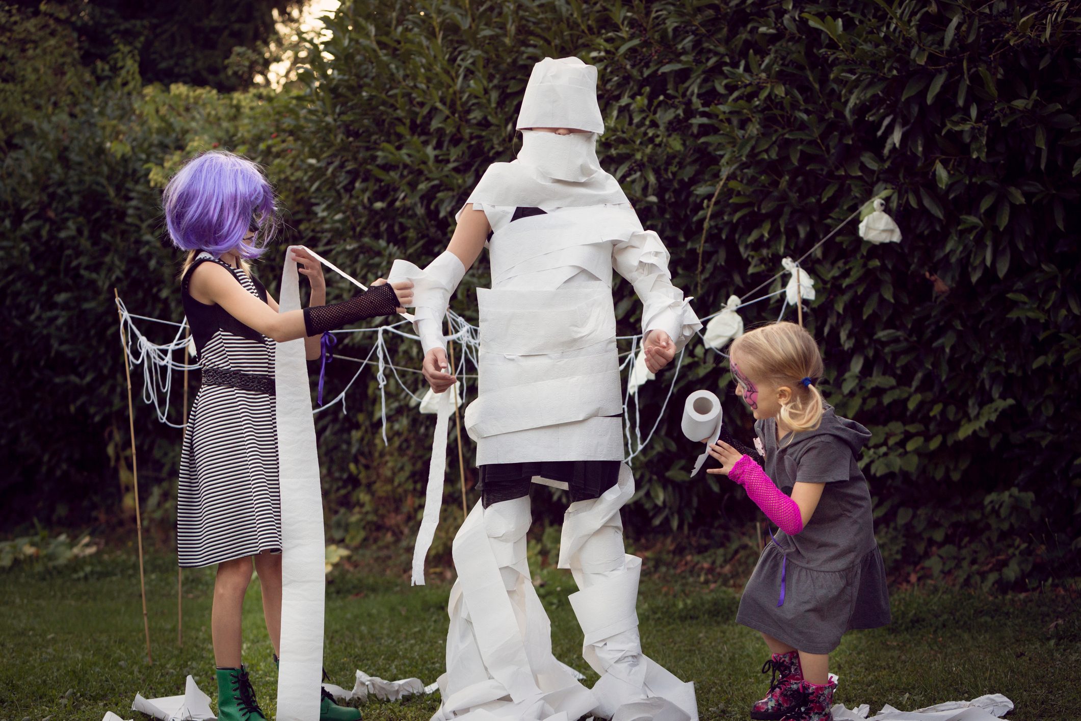 Children playing mummy wrap Halloween game