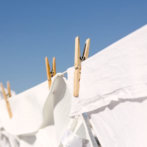 White shrunken clothes hung out to dry on a washing line in the sun.