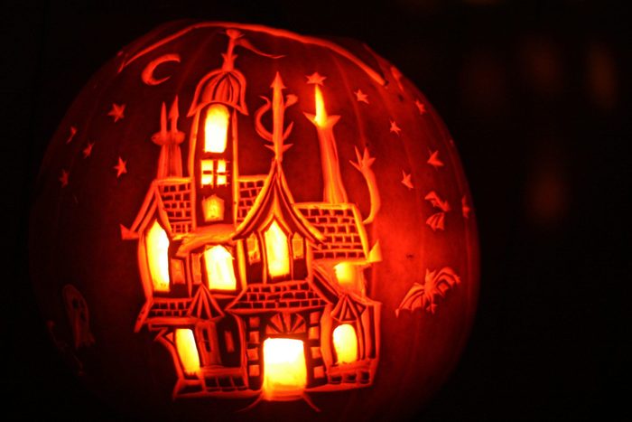 Carved pumpkin with haunted house