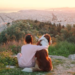 woman hugs her dog on mountain